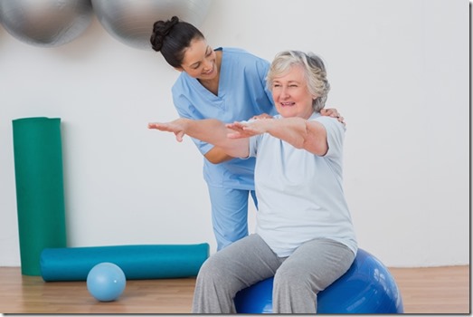 Instructor assisting senior woman in exercising