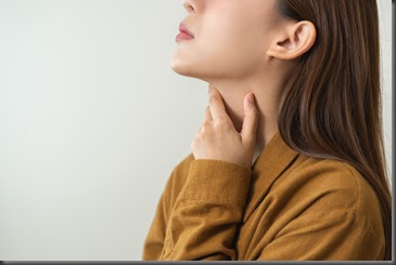 Sickness in inflaming asian young woman, girl use hand check self touch at sore throat, pain thyroid gland on neck or disease reflux, acid of suffer people on wall background. Medical and healthcare.