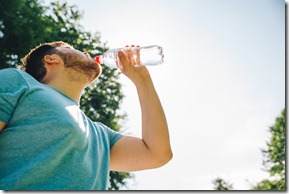 man drinking water in hot summer day. copy space