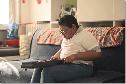 young boy plays pinball on the sofa