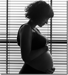 Pregnant woman standing by the window