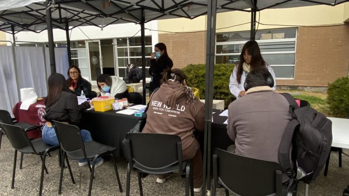 Estudiantes de la Universidad Santo Tomás realizando test rápido de VIH junto a autoridades de salud