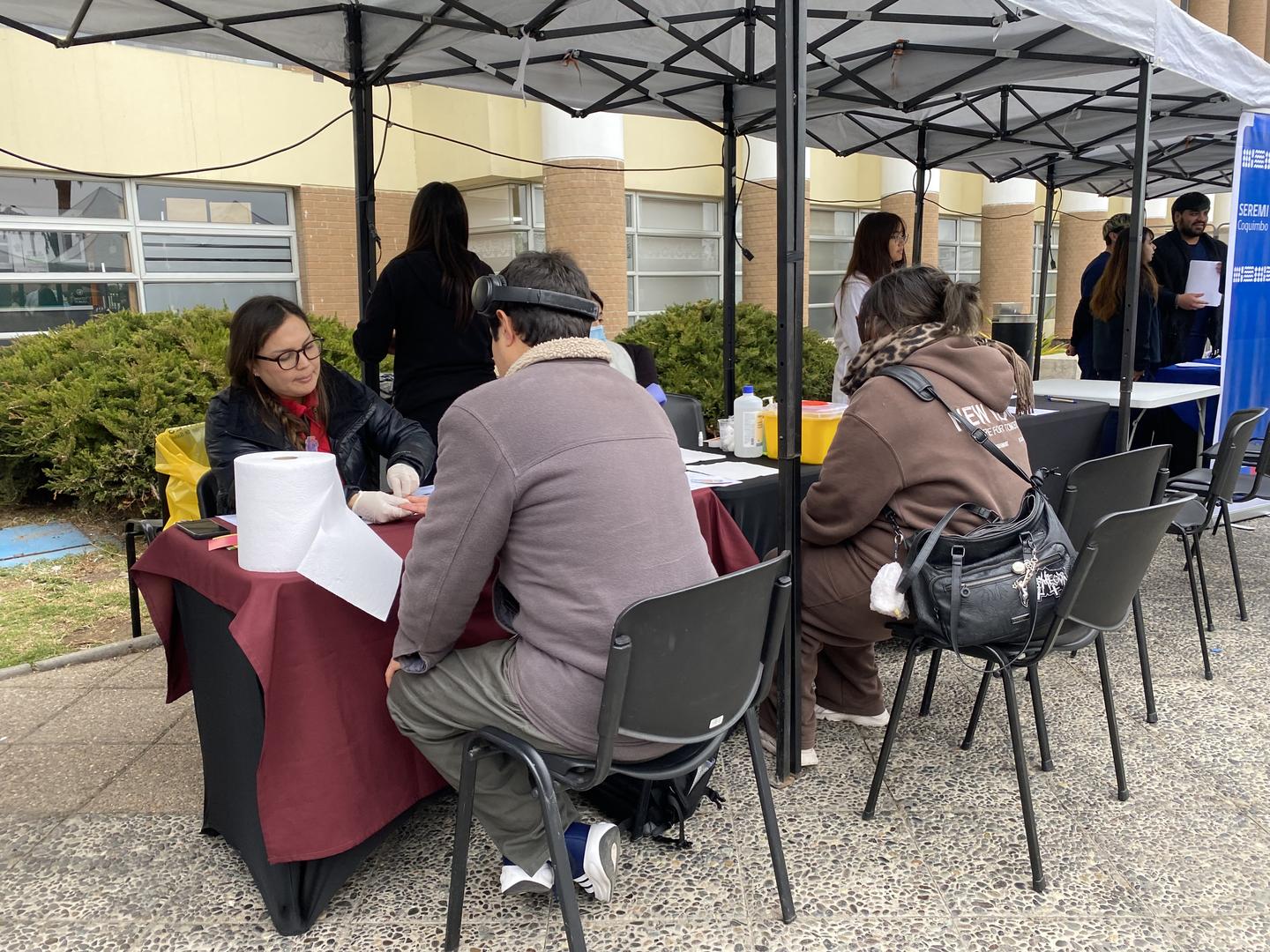 Estudiantes de la Universidad Santo Tomás realizando test rápido de VIH junto a autoridades de salud