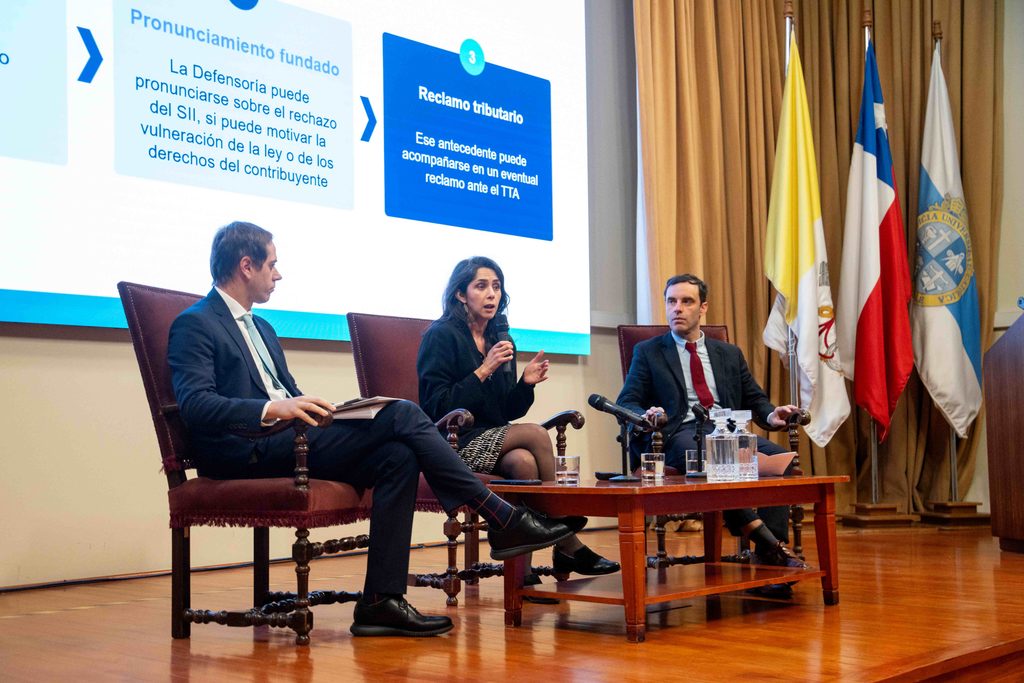 Especialistas y académicos analizando los derechos de los contribuyentes en un seminario jurídico