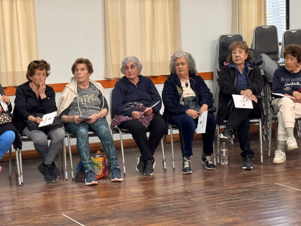 Personal de salud educando a un grupo de personas mayores sobre prevención de infecciones de transmisión sexual.