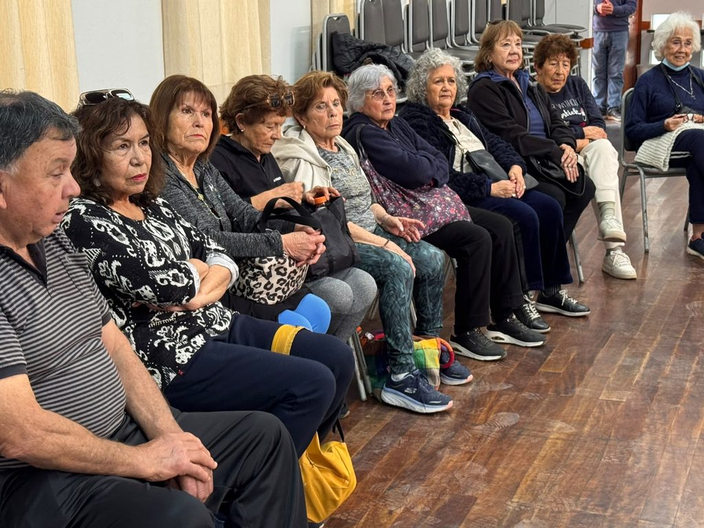 Personal de salud educando a un grupo de personas mayores sobre prevención de infecciones de transmisión sexual.