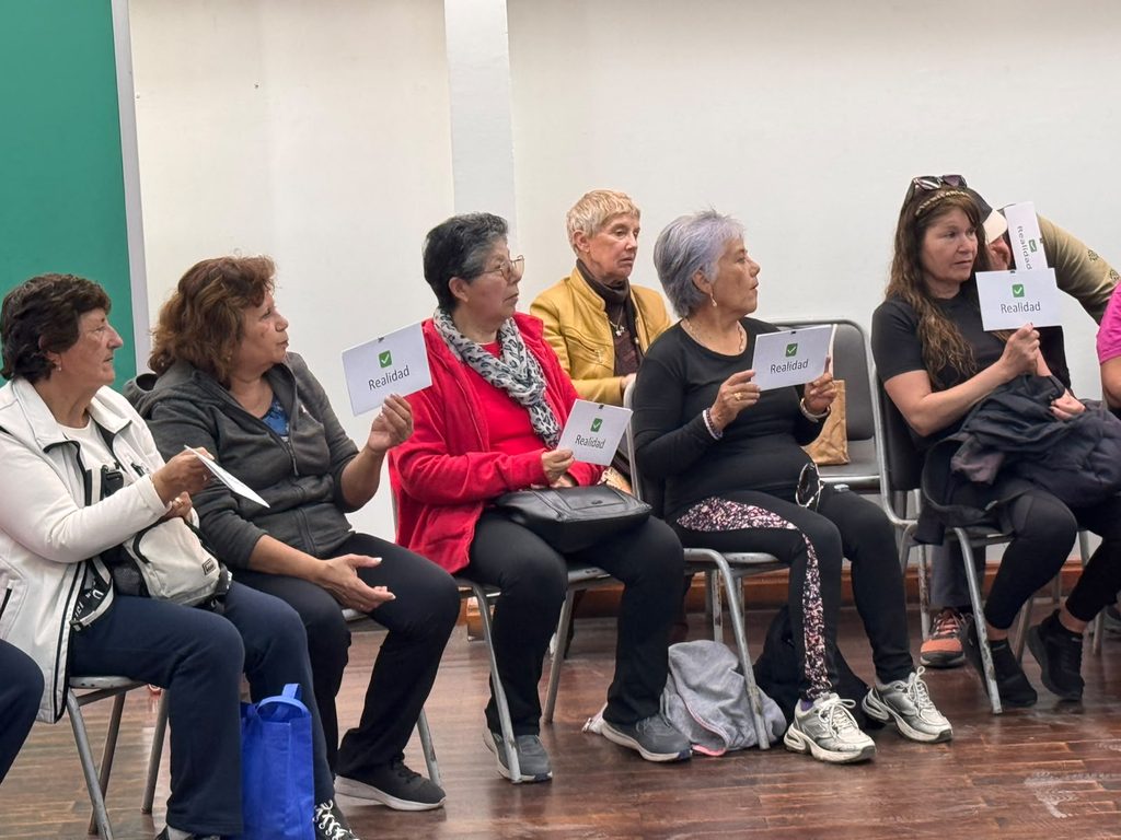 Personal de salud educando a un grupo de personas mayores sobre prevención de infecciones de transmisión sexual.