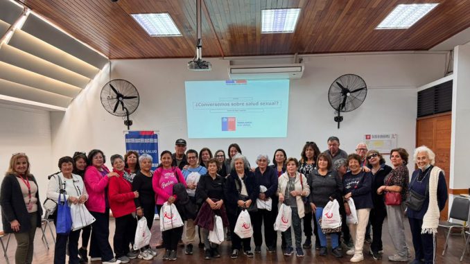 Personal de salud educando a un grupo de personas mayores sobre prevención de infecciones de transmisión sexual.