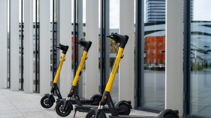 Usuario utilizando un scooter eléctrico compartido en una calle urbana de Santiago