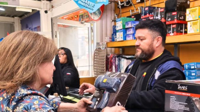 Mujer utilizando la tarjeta digital para comprar materiales de construcción en una ferretería