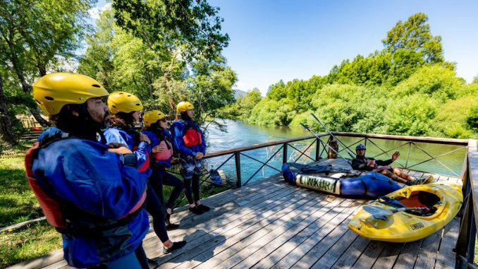 Personas practicando rafting y turismo aventura en un río