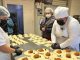 Autoridad sanitaria inspeccionando condiciones de higiene en una fábrica de empanadas