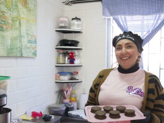 Madre sonriente trabajando en su emprendimiento de repostería en Coquimbo en honor a su hijo