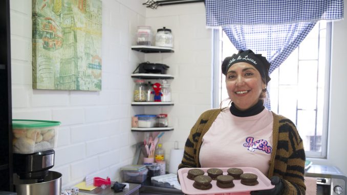 Madre sonriente trabajando en su emprendimiento de repostería en Coquimbo en honor a su hijo